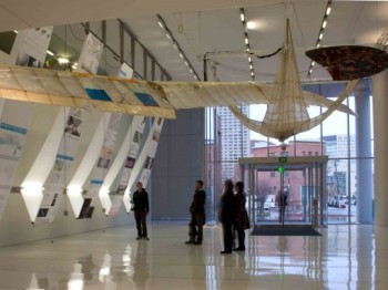 Building atrium with large sculptures and banners suspended from the ceiling.