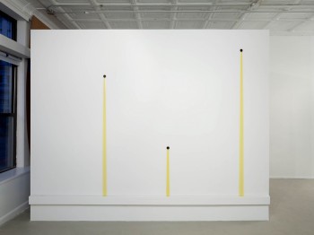 A white wall with yellow lines coming down from three holes.