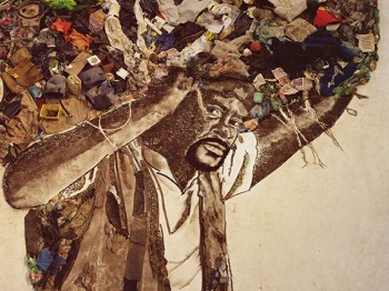 Image of a man holding a large sphere made of garbage