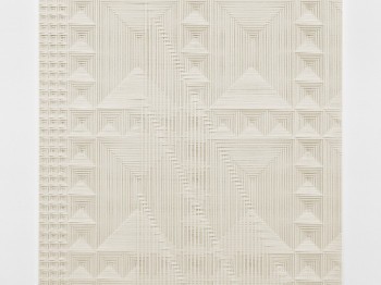 Geometric patterns in a beige panel on a wall.