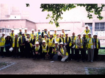A group wearing hardhats and yellow vests poses for a photo.
