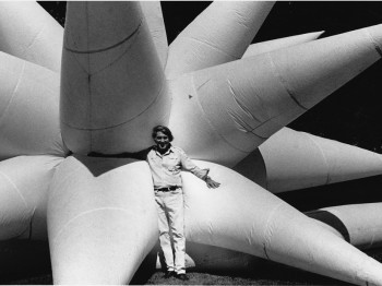 A man poses with a large star-shaped inflatable structure.