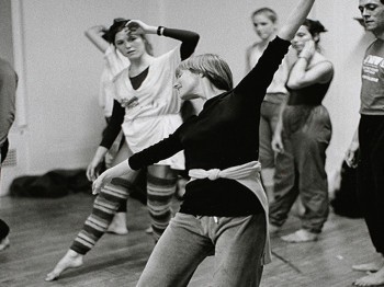 An instructor demonstrates for students in a dance class.