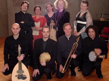 Nine musicians holding instruments pose for a photograph.