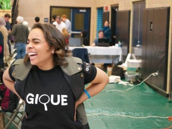 A woman laughing in a busy room.