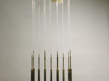 A device made of gears with long thin poles topped with pieces of paper.