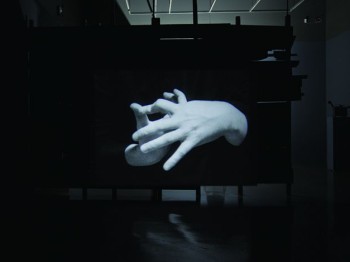 Projected image of two hands making shapes.