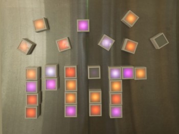 Small colorful illuminated cubes are arranged to spell "MIT."