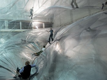 People play on large inflated plastic structures.