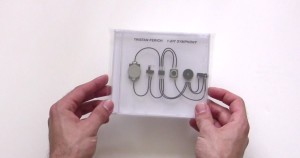 Hands hold a CD case depicting small chips connected by wires