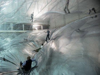 People play and move on a large multi-layer inflated plastic installation.