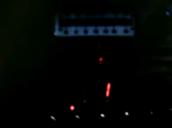 Blurry image of dark shapes and red light