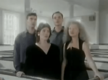 Blurry video still of four singers in a church pew