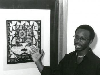 A student gestures toward a black and white woodcut.
