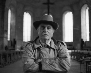 A man poses for a photograph in a stone church.