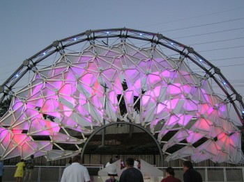 A large archway made of geometric interlocking purple and pink panels on a metal frame.