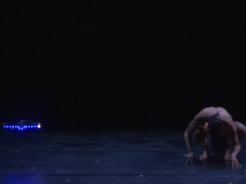 Still image from a video of a dancer with a robot.