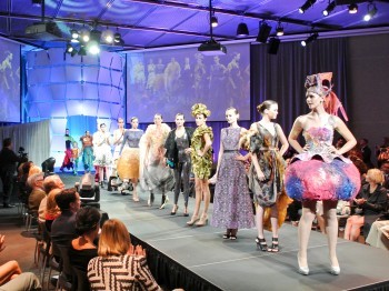 Fashion show runway featuring a line of models in colorful outfits.