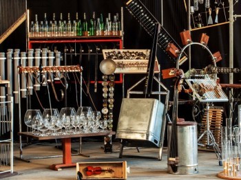 A collection of innovative musical instruments made of glasses, bottles, metal tubs, wood, and other materials.