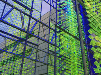 Structure with blue scaffolding and small green transparent squares.
