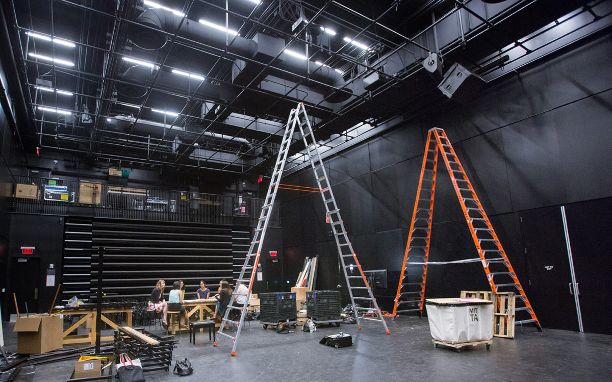 A black box theater with two ladders.
