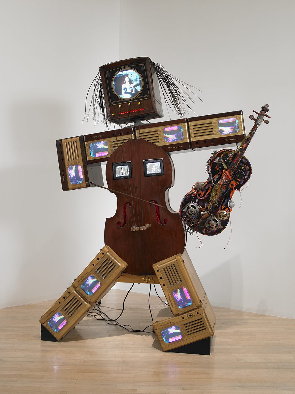 Sculpture of figure consisting of antique tv cabinets and cellos.