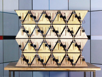 A device made of interlocking wooden triangles with other metal and wire components.