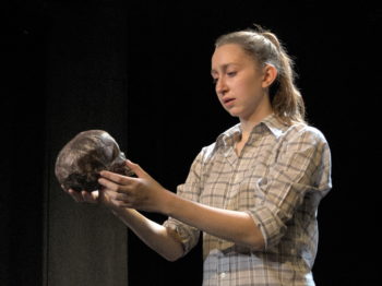 An actress holds a skull in a production of Hamlet.