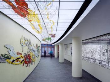 A hallway with colorful art on the ceiling and walls.