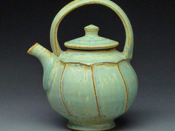 A green ceramic teapot.