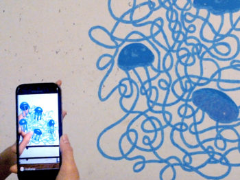 A mobile phone shows an animation of a blue wall mural.