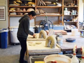 A student works in a ceramics studio.