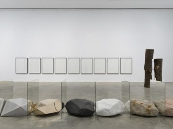 A line of metallic and textured stones in an art gallery.