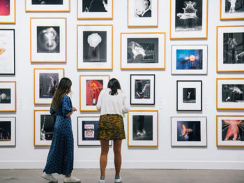 Two students explore artwork in the MIT Student Lending Art Program Exhibition. Image courtesy of the List Visual Arts Center.