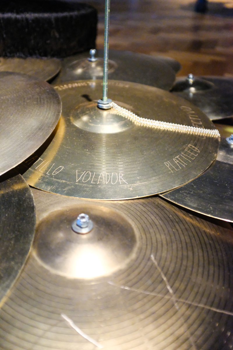 Close up view of bronze cymbals, one is engraved with obscured text.