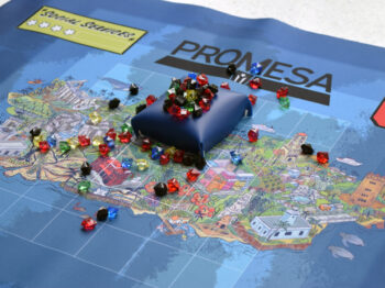 Game pieces of gem and colorful map of the Promesa Board Game.