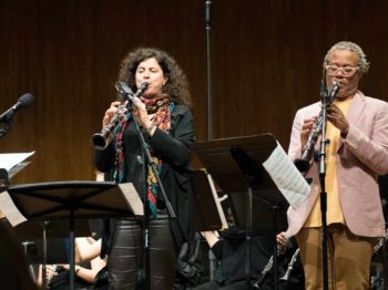 Anat Cohen and Don Byron stand on stage in MIT Kresge Auditorium and play their clarinets.