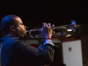 Profile view of Sean Jones playing the trumpet.