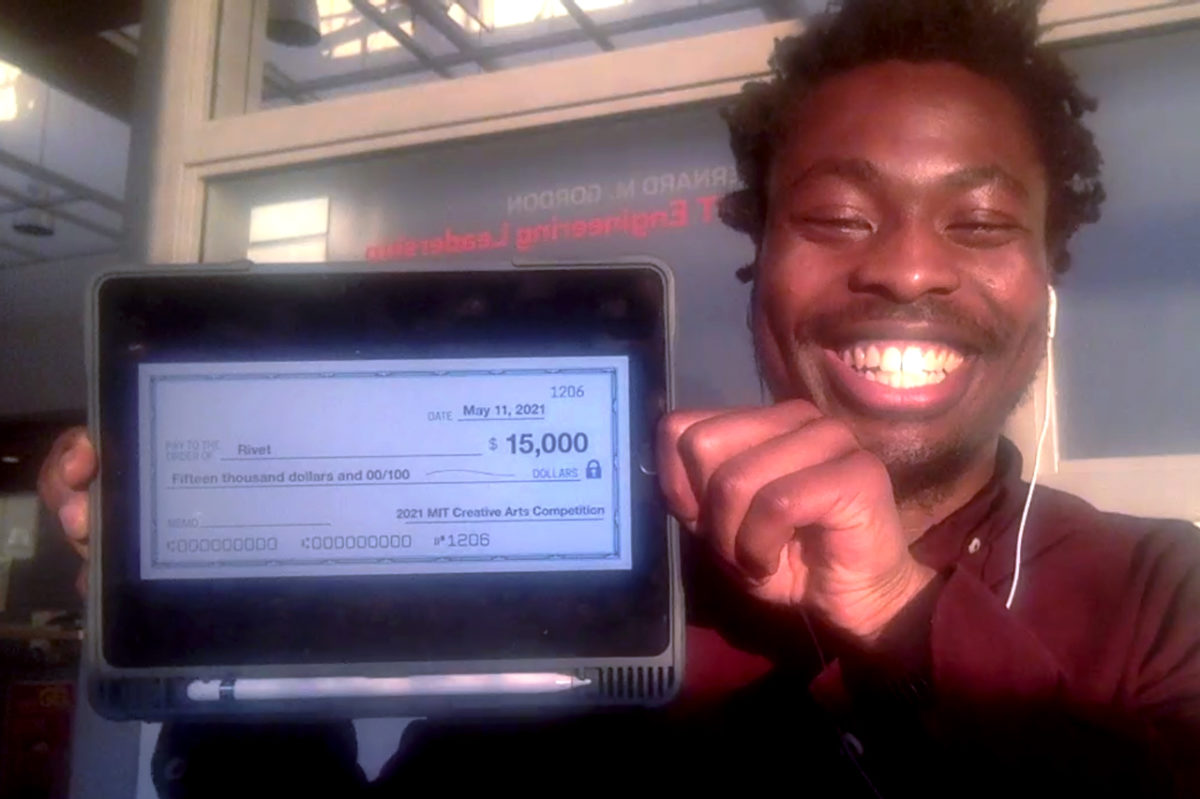 First prize recipient holds up iPad displaying an image of the $15,000 check.