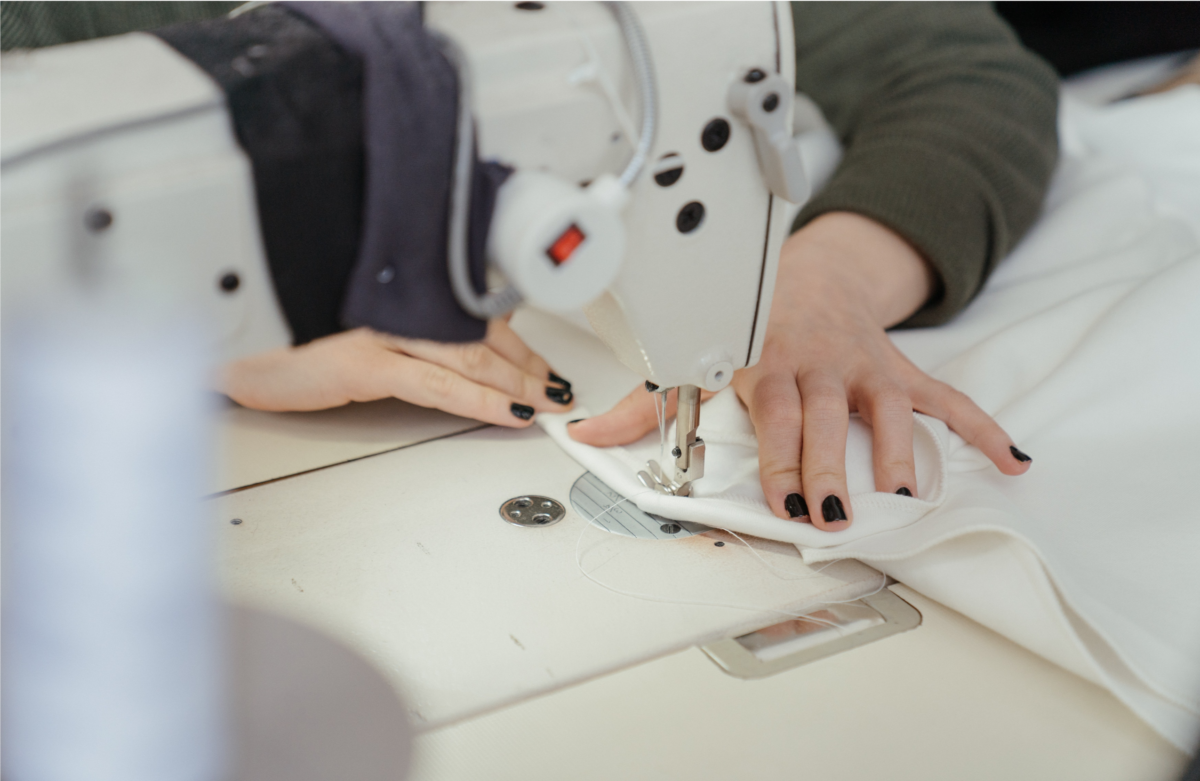 A close up view of hands using a sewing machine.
