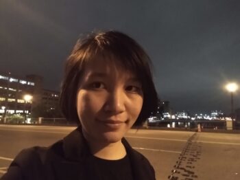 Selfie of Kerri Lu as they walk across a bridge at night.