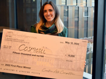 Emma Kaye smiling and holding the winning check at the 15k Creative Arts Competition.