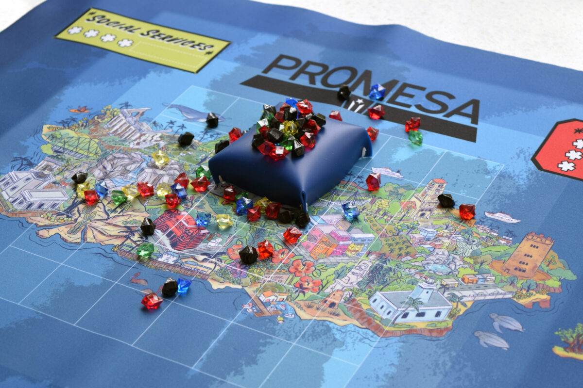 Game pieces of gem and colorful map of the Promesa Board Game.