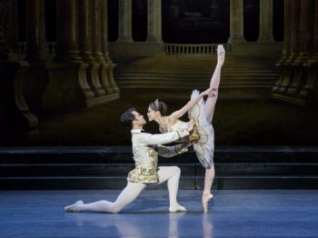 Two ballet dancers perform wearing classical costumes.