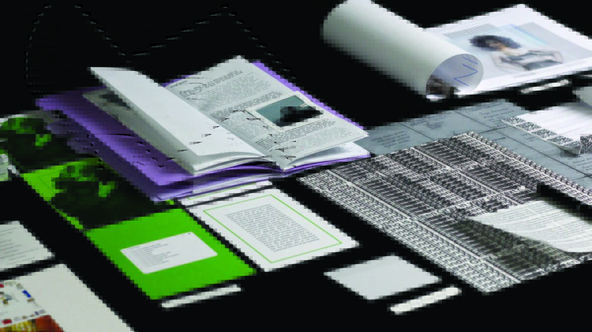 A selection of printed paper materials laid out on a black table