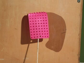 An Other Shadow, 2014-16. Arrangement of found objects with natural and painted shadows, back of wooden desk drawer, pink textured plastic, wooden stick. Credit: Lucas Blalock.
