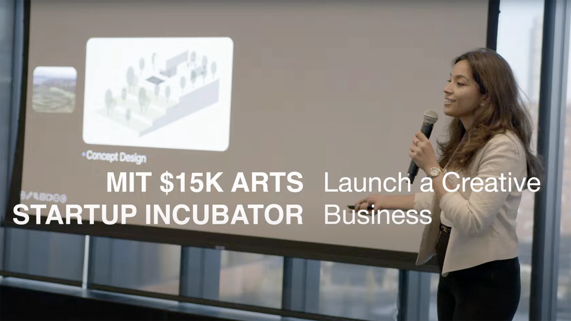 The text "MIT $15K Arts Startup Incubator, Launch a Creative Business" overlaid on a student making their pitch while holding a microphone and standing in front of a projected presentation slide.