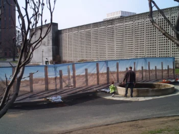 An empty street with a long corridor of fabric with an image of poles symbolizing a border