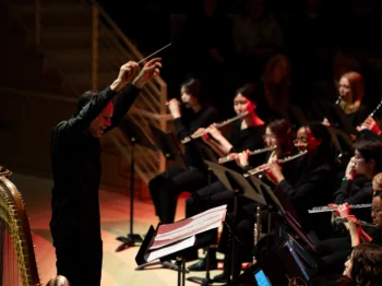 Person directing a wind orchestra with arms on the air