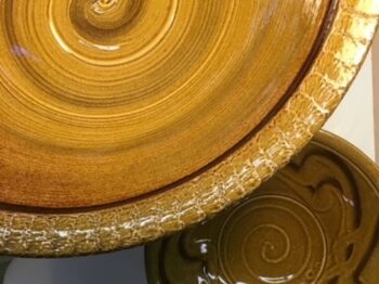 Overhead looking down color photograph of glazed ceramics bowls in Klinesville Gold.